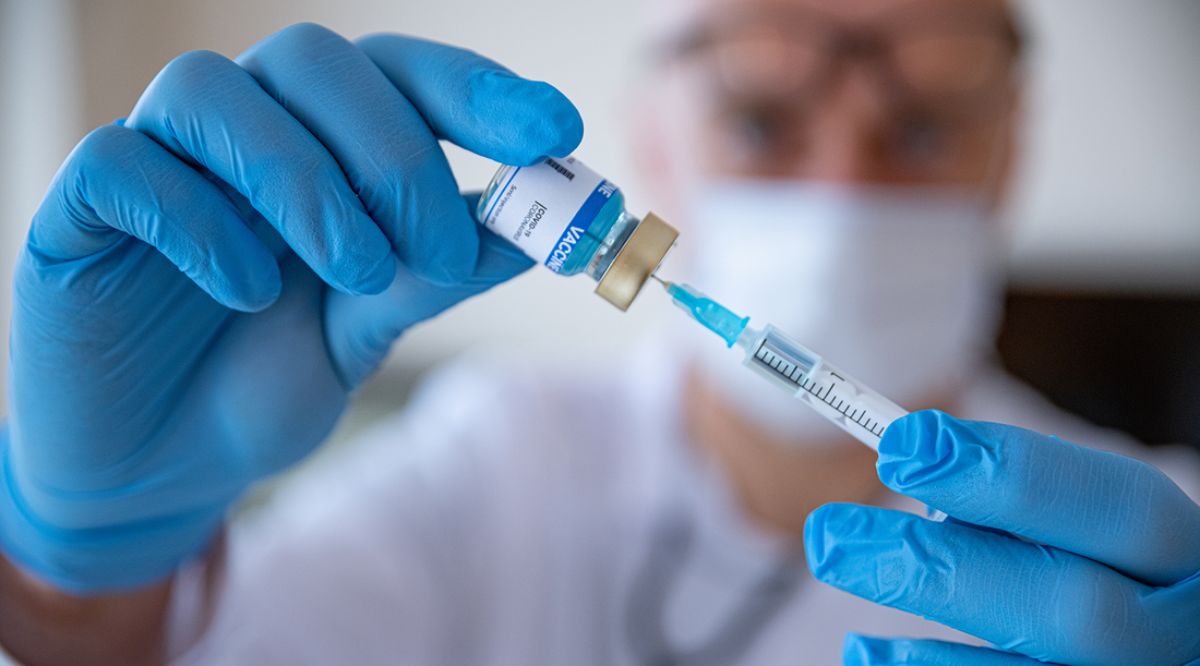 vaccine and syringe in doctors hand